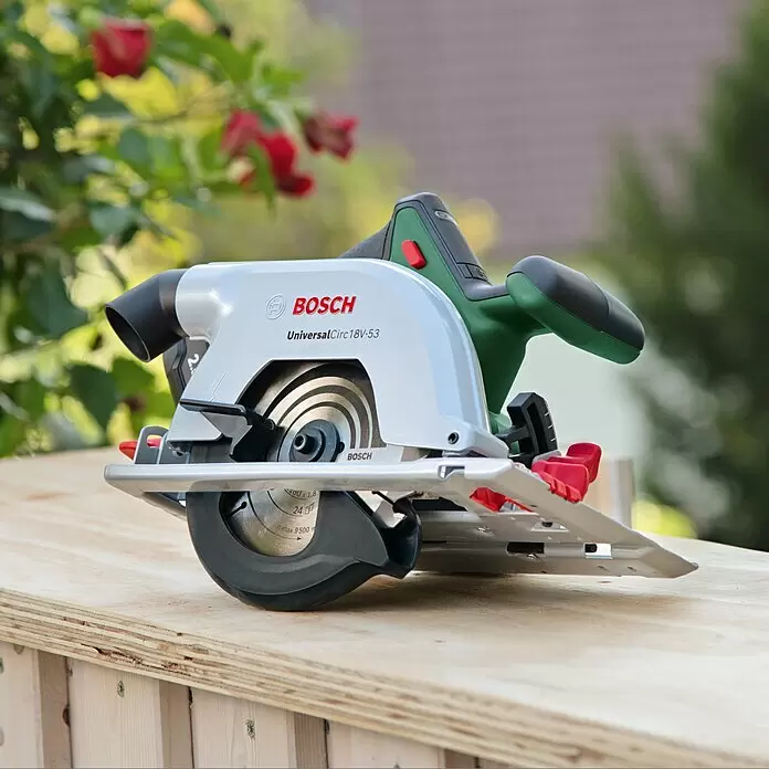Bosch Power for All 18V Akku-Handkreissäge UniversalCirc 18V-53 - 18 V, Ohne Akku, 4.300 U/min, Durchmesser Sägeblatt: 160 mm - Bosch UniversalCirc 18V-53 Handkreissäge in Silber und Grün, auf Holzbrettern positioniert.