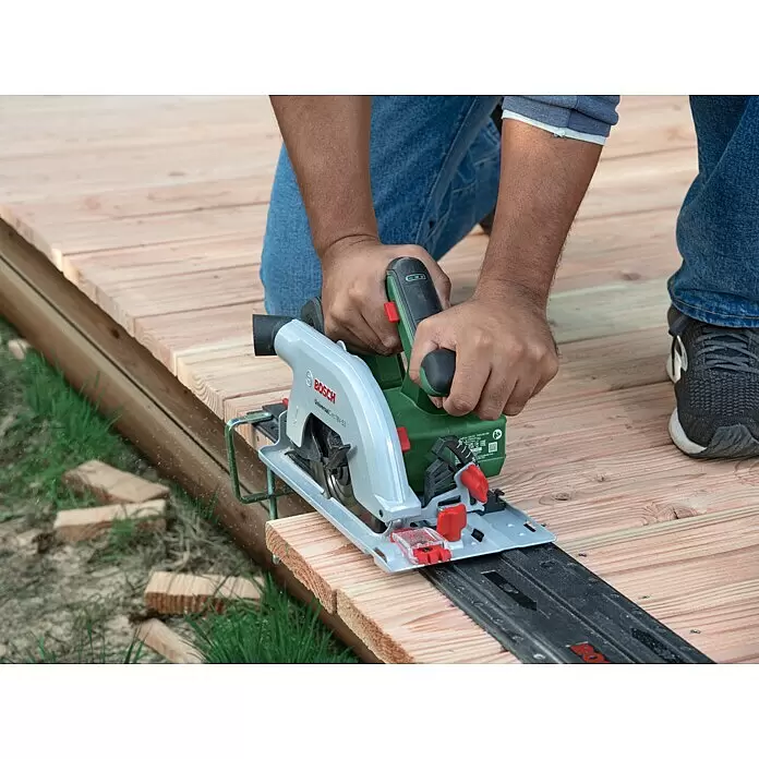 Bosch Power for All 18V Akku-Handkreissäge UniversalCirc 18V-53 - 18 V, Ohne Akku, 4.300 U/min, Durchmesser Sägeblatt: 160 mm - Eine Person sägt mit einer grünen und silbernen Bosch UniversalCirc 18V-53 Handkreissäge und Führungsschiene Holzplanken im Freien.