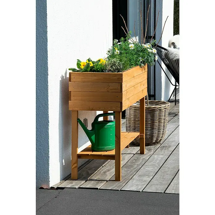 Dobar Hochbeet - L x B x H: 117 x 40 x 80 cm, Holz, Braun - Ein rustikaler Pflanztisch aus Holz mit bunten Blumen bepflanzt, neben einer grünen Gießkanne, ideal für den Garten.