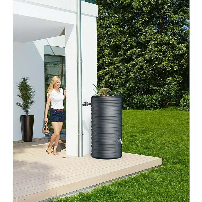Garantia Classic Line Regenspeicher Nordic 2 in 1 - 300 l, Grau - Regenwassertank in modernem Design mit Pflanzschale auf einer Terrasse neben einem Haus, ideal zur Wasserspeicherung und Gartenbewässerung.