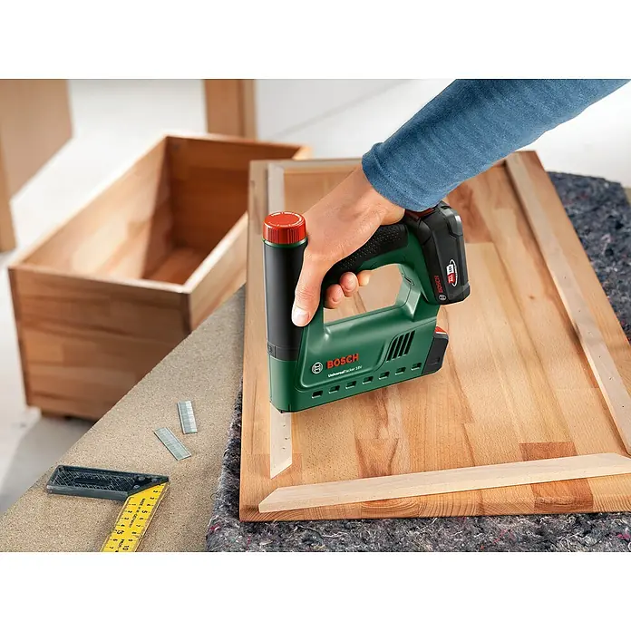 Bosch Power for All 18V Akku-Tacker UniversalTacker 18V-14 - 18 V, Ohne Akku, Klammertiefe: 6 mm - 14 mm - Der Akku-Tacker UniversalTacker 18V von Bosch bei der Arbeit, um Holzleisten zu befestigen. Ideal für Heimwerkerprojekte.