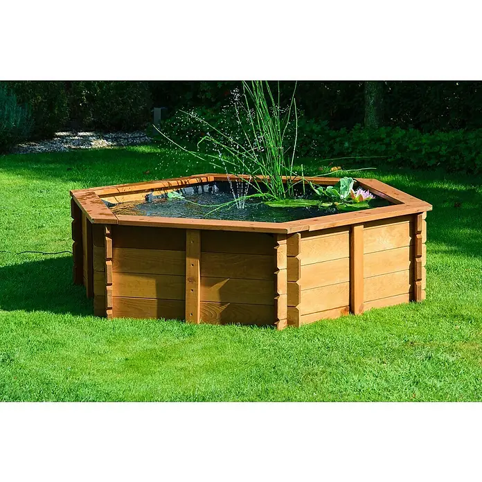 Dobar Hochteich Hexagon - L x B x H: 149 x 128,5 x 40 cm, Braun - Ein erhöhter, achteckiger Teich mit Holzumrandung, der mit Wasserpflanzen und einer Seerose gefüllt ist, steht auf einem grünen Rasen.