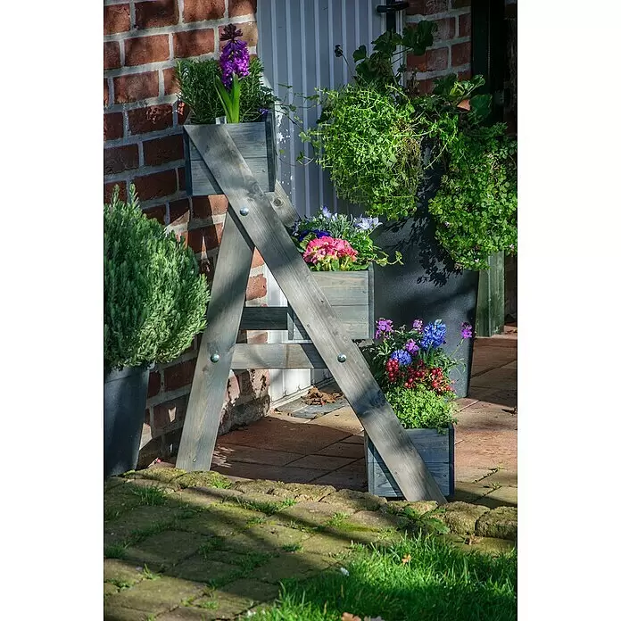 Dobar Pflanzkasten - L x B x H: 60 x 70 x 90 cm, Holz, Grau - Grauer Holzpflanzenständer mit drei Pflanzgefäßen voller bunter Blumen und grüner Pflanzen, draußen platziert.