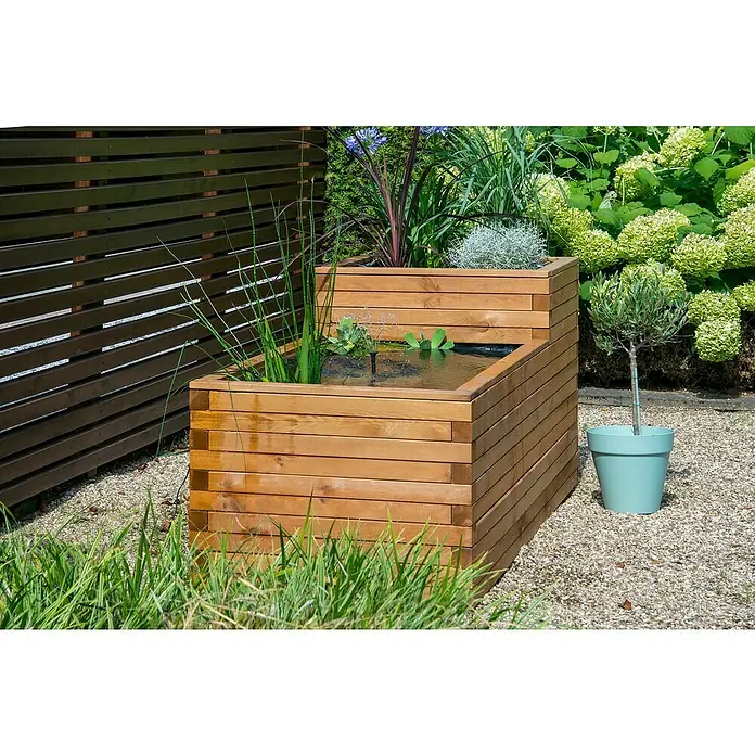 Dobar Hochteich Superb - L x B x H: 180 x 78 x 80 cm, Braun - Ein mehrstufiger Holzbrunnen mit Wasser und Pflanzen in einem Garten. Ein Olivenbaum steht in einem blaugrünen Topf daneben.