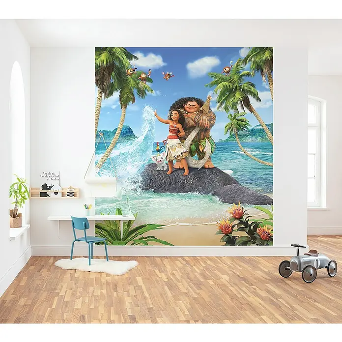 Komar Fototapete Moana Beach - B x H: 250 x 280 cm, Vlies - Ein Kinderzimmer mit einer großen Fototapete mit Motiven aus dem Film "Vaiana" und einem blauen Kinderstuhl vor einem weißen Schreibtisch.