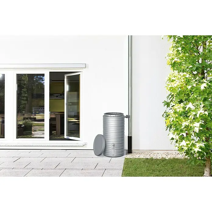 Garantia Classic Line Regenspeicher Nordic - 300 l, Steingrau - Regenwassertonne neben einem Fallrohr an einer Hauswand.