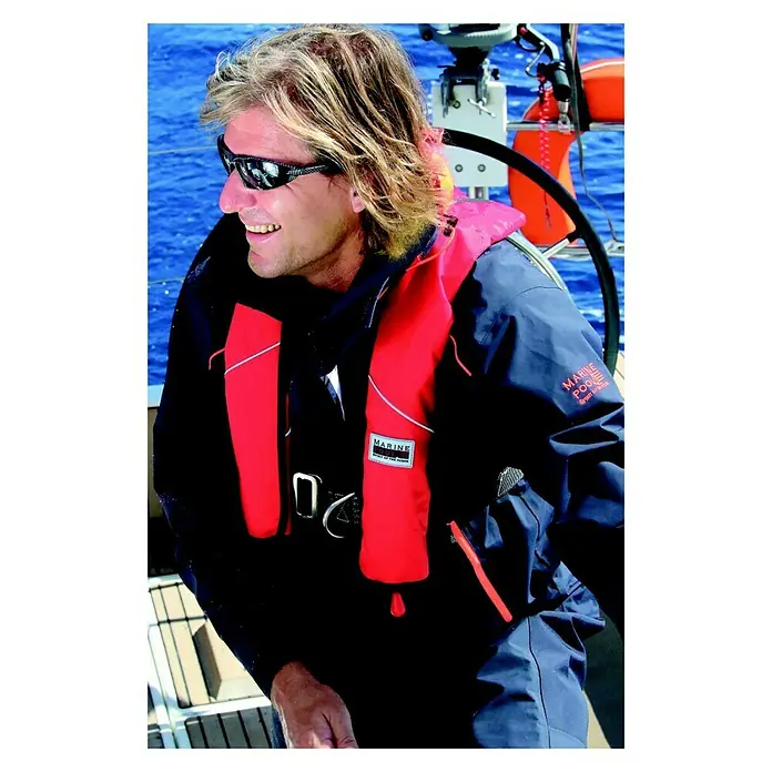 Marinepool Automatik-Rettungsweste Racer 180N - 180 N, Automat United Moulders MK2 Pro Sensor, 40 kg - Ein Mann mit Sonnenbrille und einer roten Marinepool-Schwimmweste an Bord eines Bootes auf dem Meer.