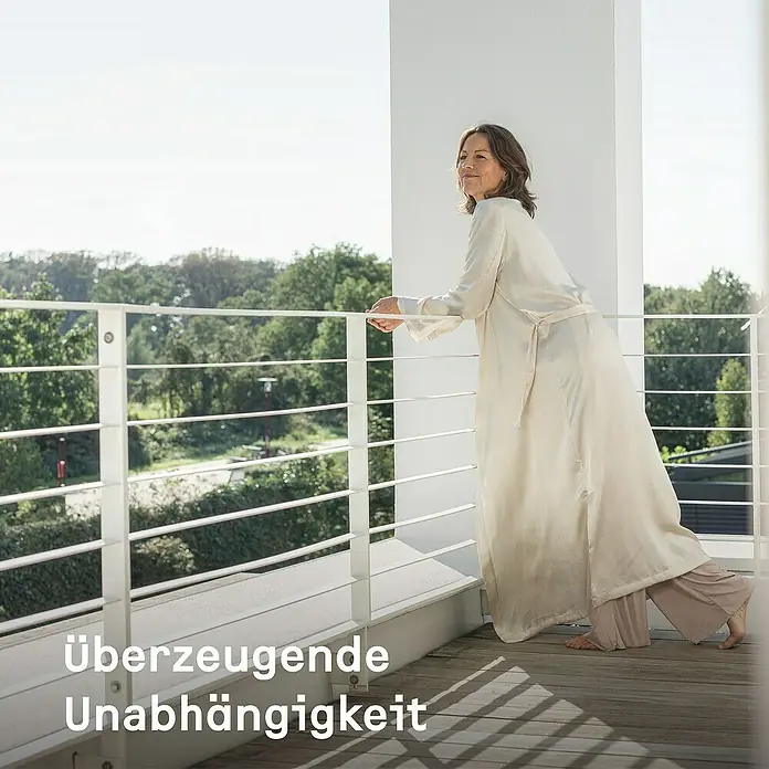 Stiebel Eltron Warmwasser-Wärmepumpe WWK 300 Sol electronic - Heizleistung: 1,3 kW - 1,6 kW, Fassungsvermögen: 291 l - Frau in eleganter Morgenmantelgarnitur auf einem Balkon mit dem Text "Überzeugende Unabhängigkeit".