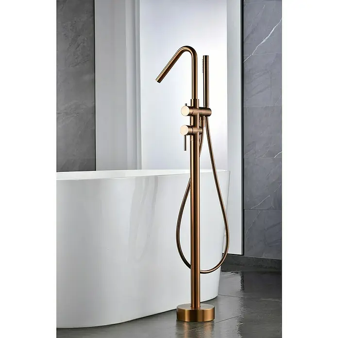 Camargue Natur Grifo para bañera - Oro rosa - Grifo de bañera independiente de oro cepillado con ducha de mano junto a una bañera blanca para un diseño de baño lujoso.
