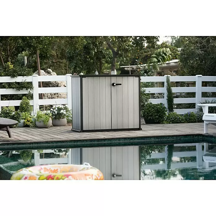 Keter Truhe Patio Store - L x B x H: 73,6 x 140 x 120 cm, Grau - Grauer und schwarzer Outdoor-Lagerschrank mit zwei Türen auf einem Holzdeck am Pool.
