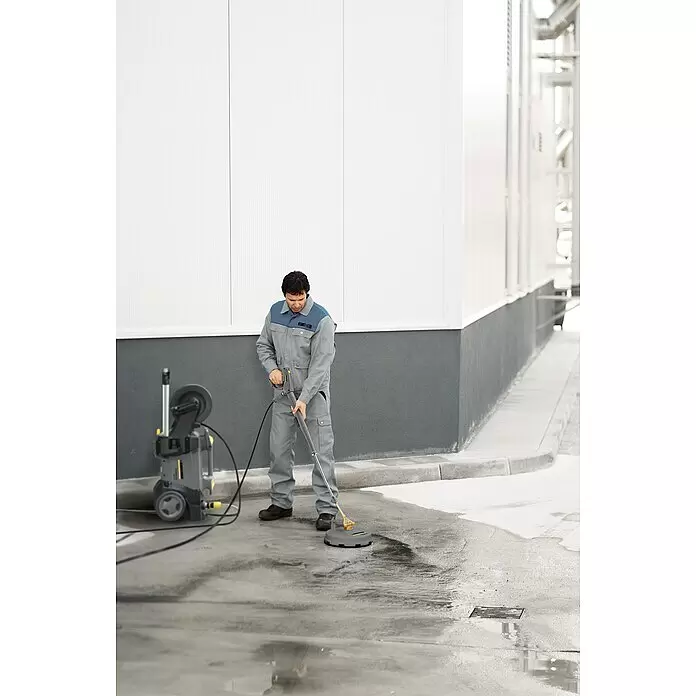 Kärcher Flächenreiniger FR 30 - Durchmesser: 300 mm - Mann reinigt Betonboden mit einem grau-gelben Hochdruckreiniger-Flächenreiniger.