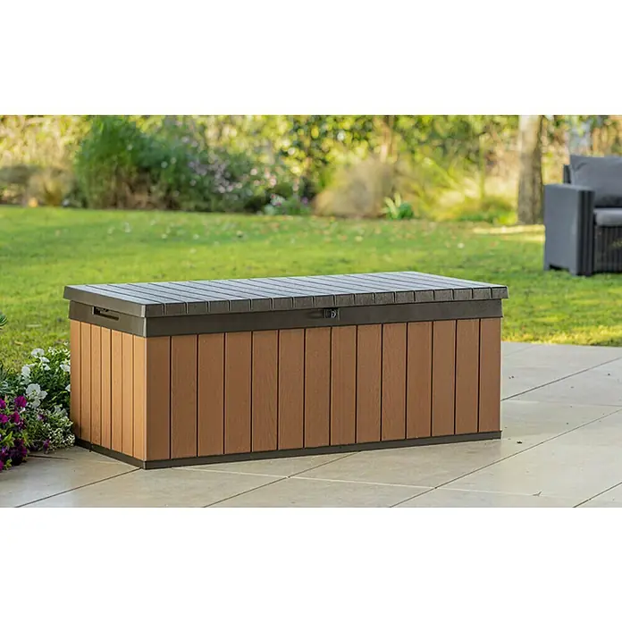 Baúl para jardín Darwin 100 - L x An x Al: 65 x 143 x 55 cm, Marrón - Una caja de almacenamiento marrón para exteriores con tapa oscura se encuentra en un patio, ideal para guardar herramientas de jardín.