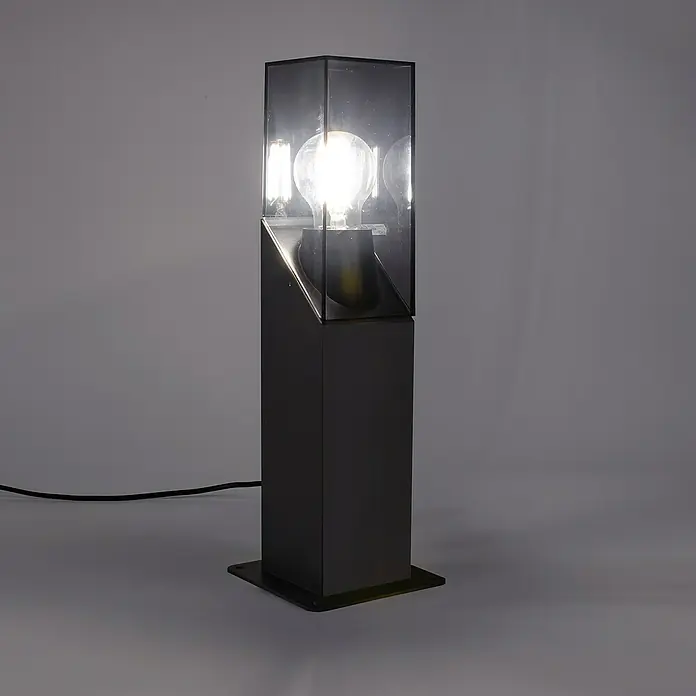 Forlight Munic Lámpara de pie para exterior - 15 W, Color del marco: Antracita, 13 x 13 x 40 cm, Sin bombillas - Elegante lámpara de pie con diseño moderno, que presenta una base negra y un recinto de vidrio transparente que muestra una bombilla brillante.
