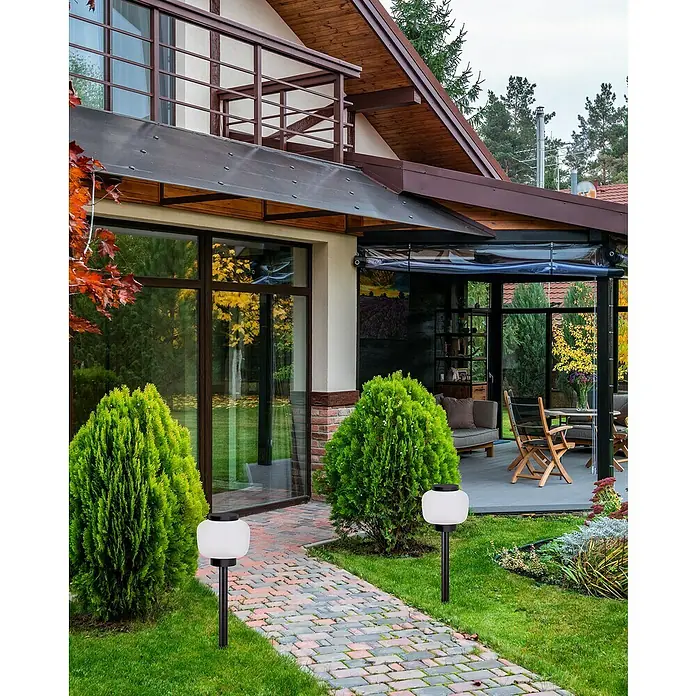 Forlight Lámpara de pie para exterior Lamtam - 15 W, Sin bombillas - Fachada de una casa con sendero iluminado por dos farolas esféricas de jardín.