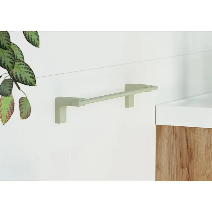 Creabath Elegance Toallero de barra - 35,6 cm, Verde mist - Una barra de toalla verde claro está montada en una pared blanca, junto a una planta y un tocador con detalles de madera.