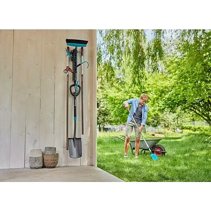 Gardena Halterung Einzelstecker Flex - Passend für: GARDENA combisystem, das Original GARDENA System & Scheren - Gardena Wandhalterung für Gartengeräte: Besen, Spaten und Schere, in Schwarz-Blau, an Holzwand im Garten.