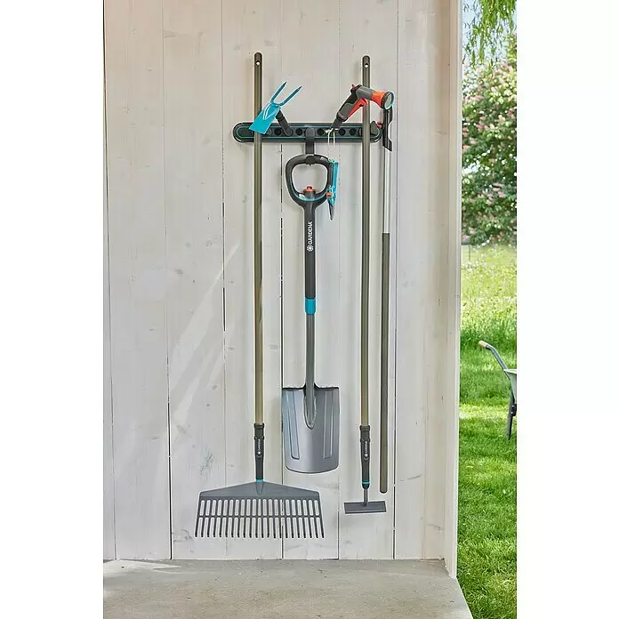 Gardena Halterung Flex - 10 kg, Kunststoff - Sortiment dunkelgrauer und schwarzer Gartengeräte mit blauen und orangen Akzenten, ordentlich an einer Wandhalterung organisiert.