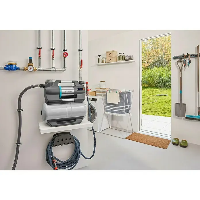 Gardena Hauswasserwerk 6300 Silent Comfort - 1.050 W, Max. Fördermenge: 6.300 l/h, Max. Druck: 4,9 bar - Bild eines Gardena Hauswasserautomaten mit Zubehör in einem Hauswirtschaftsraum, ideal für die Gartenbewässerung und Hauswasserversorgung.