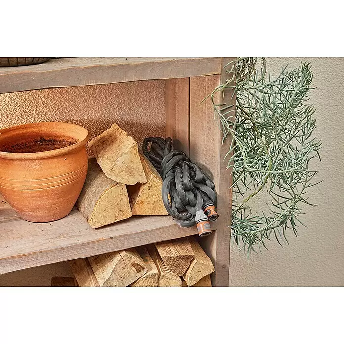 Gardena Gartenschlauch Liano Life Set - 15 m, Schlauchdurchmesser: 13 mm - Grauer, aufgerollter Gartenschlauch mit orange-grauen Anschlüssen, auf einem Holzregal gelagert.