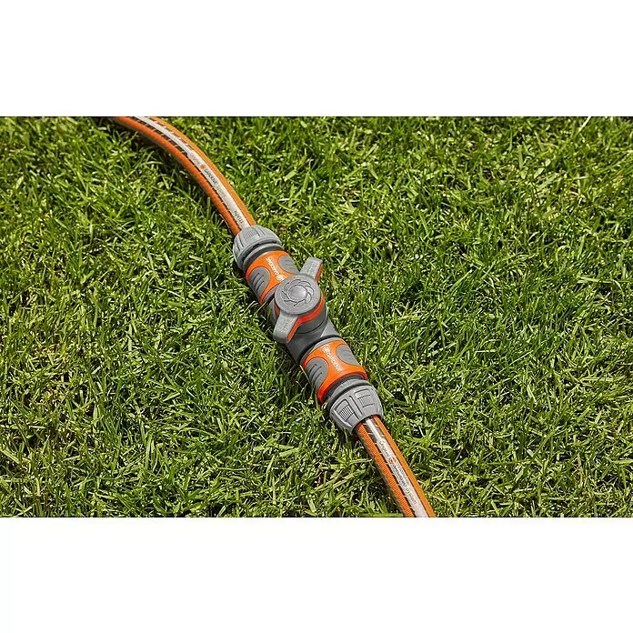 Gardena Schlauchkupplung mit Regulierventil - Frostbeständig, Geeignet für: Gartenschläuche - Oranger und grauer Gardena Schlauchverbinder mit Ventil, an einem Gartenschlauch.