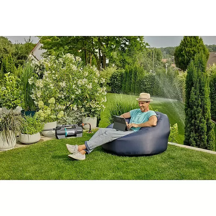 Gardena Gartenpumpe 5600 Silent+ - 900 W, Max. Fördermenge: 5.600 l/h - Gardena Pumpe (grau/schwarz, blauer Akzent) auf Rasen, an Regner angeschlossen, bewässert einen Garten.