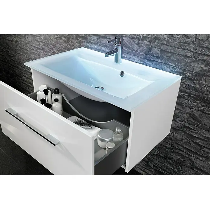 Camargue Stella Waschtischunterschrank - 99,4 x 48,8 x 39 cm, Mit Beleuchtung, Weiß - Ein moderner Waschtisch mit einer weißen Schublade, die verschiedene Badutensilien enthält, vor einer dunklen Steinwand.