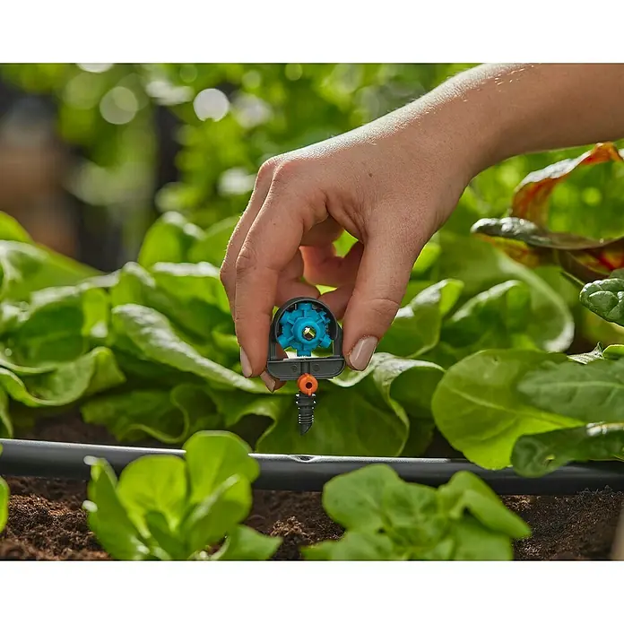 Gardena Micro-Drip Tobera pulverizadora - Diámetro conexión: 13 mm, Técnica de unión Quick & Easy - Primer plano de una mano instalando un gotero final ajustable GARDENA Micro-Drip-System, asegurando un riego eficiente de las plantas.