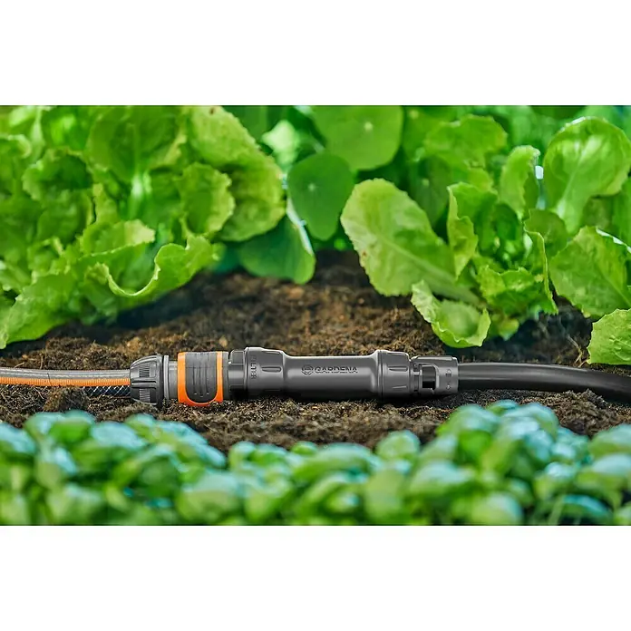 Gardena Micro-Drip Hahnanschlussstück - 1/2" x 13 mm - Nahaufnahme eines Gardena Micro-Drip-Systems, das in einem Gartenbeet installiert ist, um Pflanzen effizient zu bewässern.