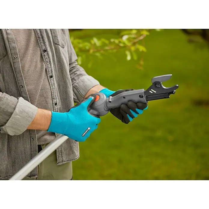 Gardena Power for All 18V Cortarramas de jardín HighCut 360/18V P4A - 18 V, Sin batería, Grosor de rama máx.: 28 mm, Largo: 360 cm - Una persona usa podadora de altura telescópica Gardena para podar ramas, con guantes de jardinería azules y negros.