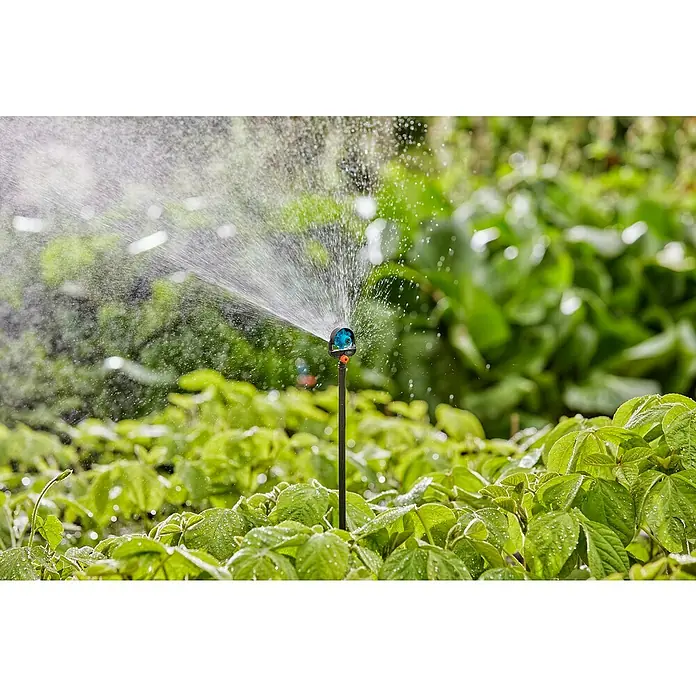 Gardena Micro-Drip Tubo prolongador para boquillas pulverizadoras - 5 ud., Largo: 20 cm - El aspersor rocía agua sobre plantas verdes, asegurando un riego eficiente del jardín.