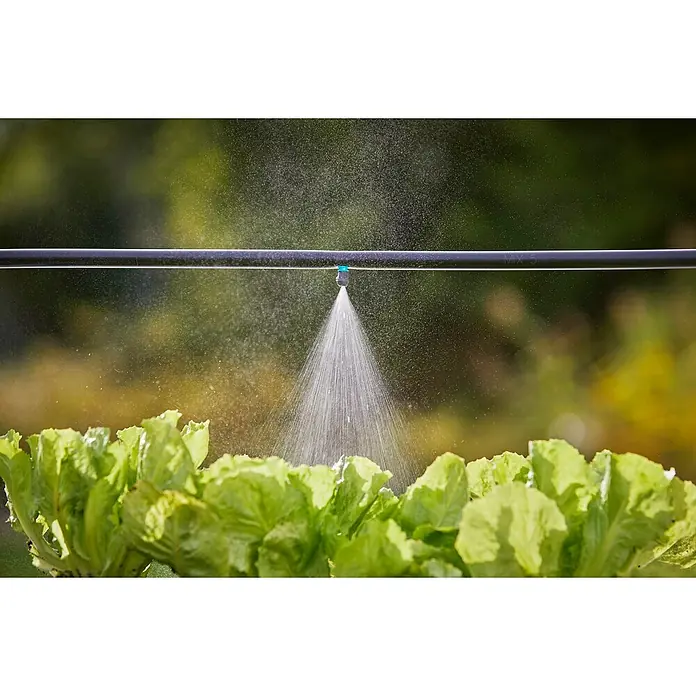 Gardena Micro-Drip Nebeldüse - 1/2" x 13 mm - Nahaufnahme einer Beregnungsanlage, die Wasser auf ein Feld mit Salat sprüht.