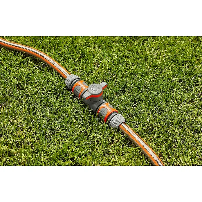 Gardena Schlauchkupplung mit Regulierventil - Frostbeständig, Geeignet für: Gartenschläuche - Nahaufnahme eines Gardena-Wasserhahns an einem Gartenschlauch auf einem grünen Rasen. Praktisch für präzise Bewässerung und Gartenarbeit.