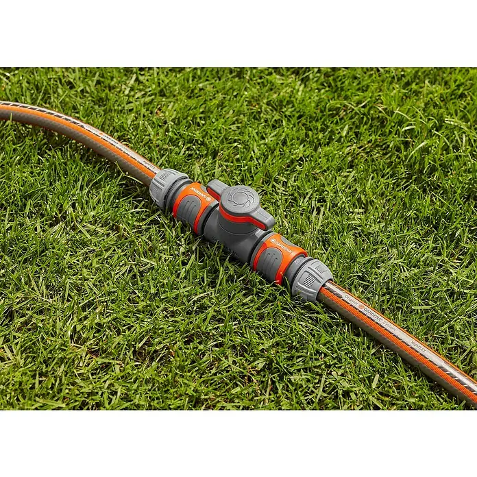 Gardena Schlauchkupplung mit Regulierventil - Frostbeständig, Geeignet für: Gartenschläuche - Nahaufnahme eines Gardena-Schlauchstücks mit Absperrventil auf grünem Gras, das Original Gardena System für Bewässerung.