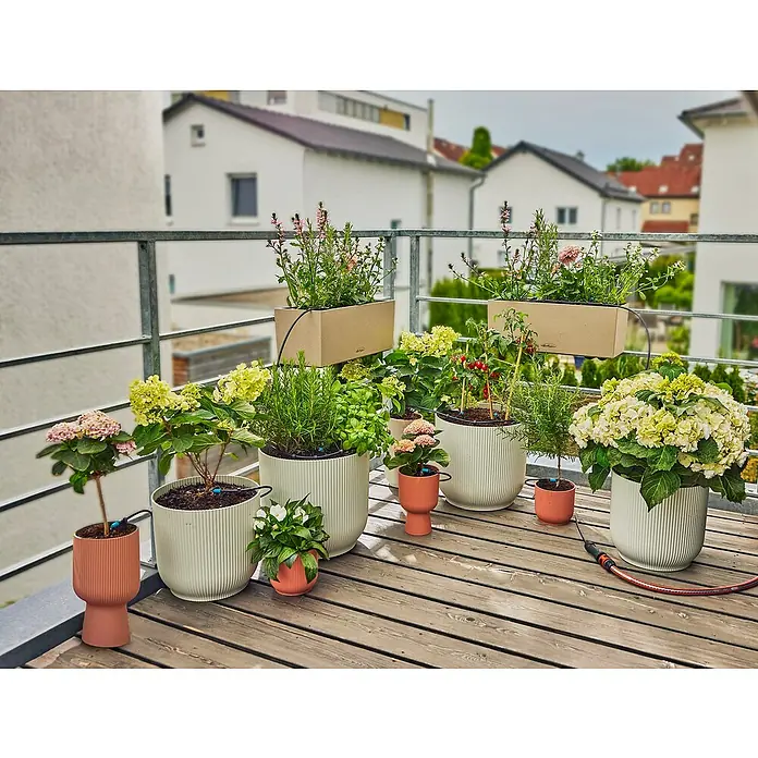 Gardena Micro-Drip Kit de riego - Específico para: Hasta 15 plantas en maceta - Variedad de macetas y jardineras en una terraza de madera, que ofrecen una experiencia de jardinería exuberante y colorida.