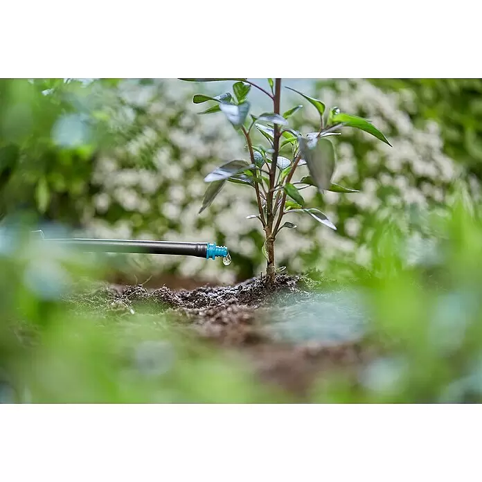 Gardena Micro-Drip Endtropfer - 25 Stk., Max. Wasserdurchfluss: 2 l/h - Ein schwarzer Tropfbewässerungsschlauch mit blauem Emitter tropft Wasser auf die Erde neben einer kleinen grünen Pflanze.