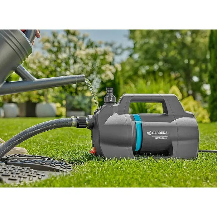 Gardena Gartenpumpen-Set 4200 Silent - 600 W, Max. Fördermenge: 4.200 l/h - Nahaufnahme einer Gardena 4200 Silent Gartenpumpe, die mit einem Gartenschlauch und einer Gießkanne verbunden ist, auf einem Rasen.
