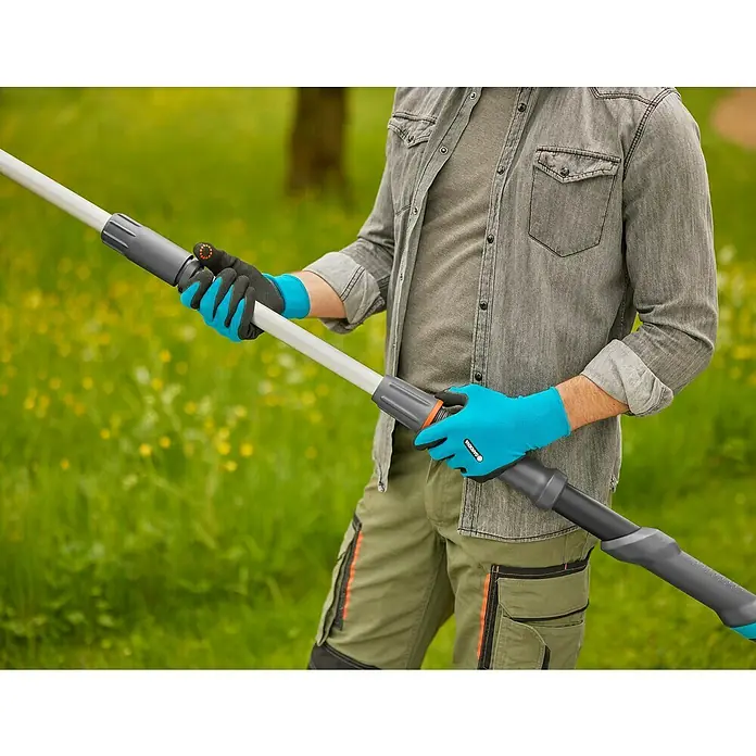 Gardena Power for All 18V Cortarramas de jardín HighCut - 18 V, Sin batería, Grosor de rama máx.: 28 mm, Largo: 255,7 cm - Una persona sostiene una tijera de podar extensible con guantes azules, ideal para tareas de poda de árboles.