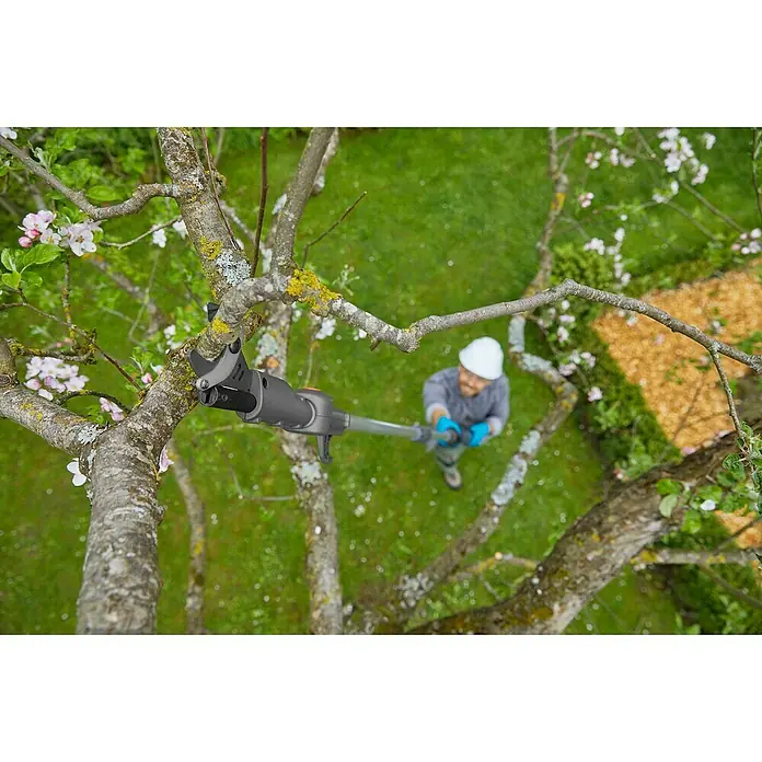 Gardena Power for All 18V Cortarramas de jardín HighCut 360/18V P4A - 18 V, Sin batería, Grosor de rama máx.: 28 mm, Largo: 360 cm - Vista superior de un hombre con casco que utiliza un podador de árboles GARDENA para podar un árbol. El césped es verde.