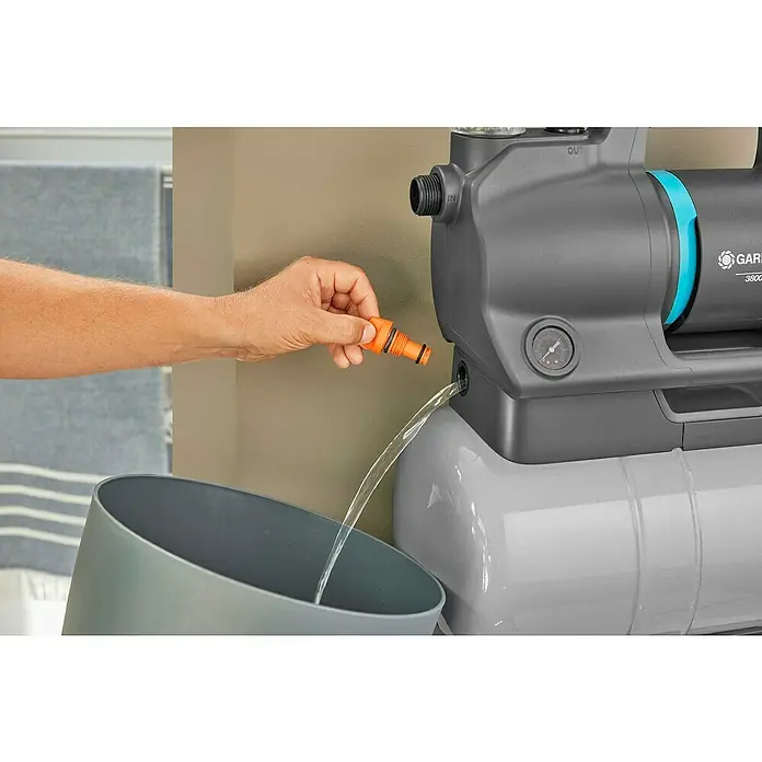 Gardena Hauswasserwerk 3900 Silent - 650 W, Max. Fördermenge: 3.900 l/h, Max. Druck: 4,3 bar - Eine Gardena Gartenpumpe wird entleert, wobei ein orangefarbener Adapteranschluss und ein grauer Eimer verwendet werden.