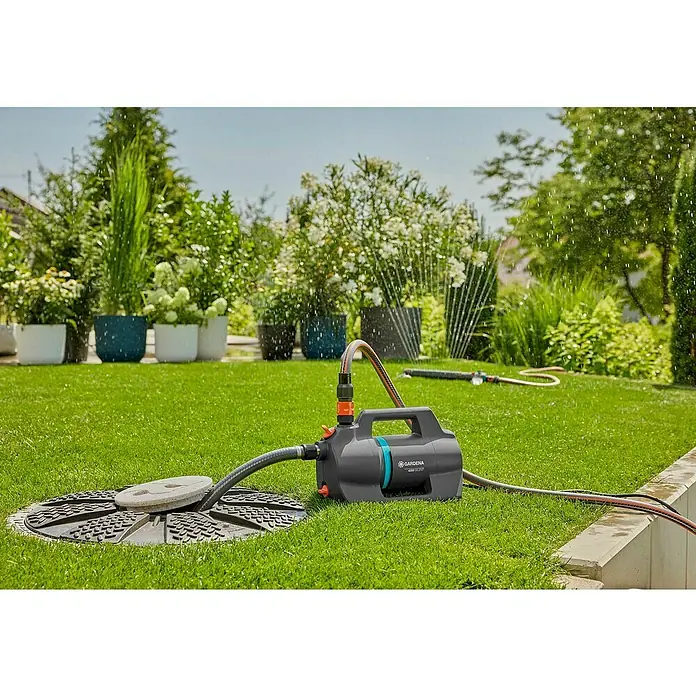 Gardena Gartenpumpe 4200 Silent - 600 W, Max. Fördermenge: 4.200 l/h - Eine Gardena Gartenpumpe liegt auf dem Rasen und bewässert den Garten mit einem Rasensprenger. Perfekt für die Gartenbewässerung.