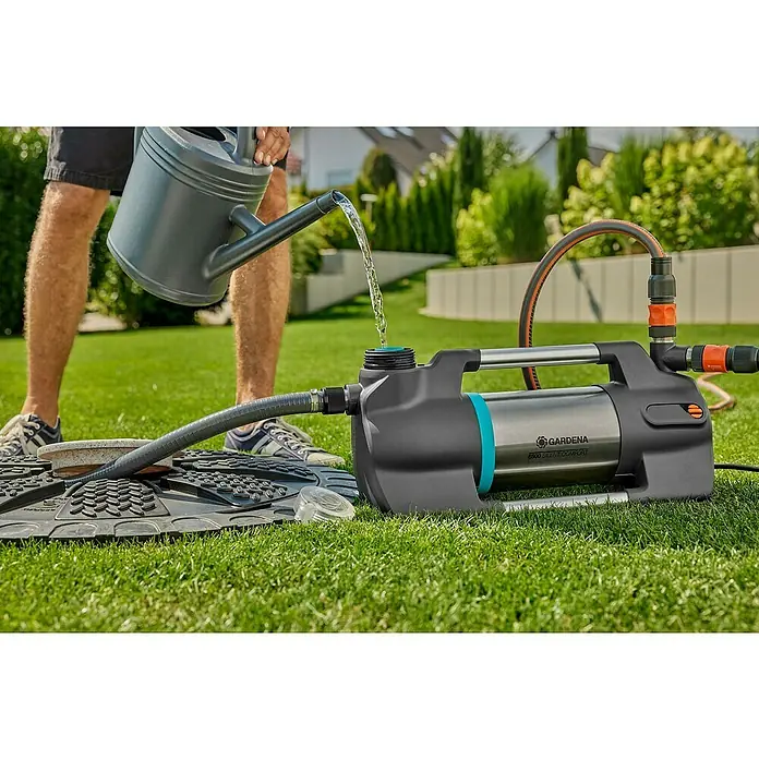 Gardena Gartenpumpe 6500 SilentComfort - 1.300 W, Max. Fördermenge: 6.500 l/h - Ein Mann befüllt eine Gardena 6500 Silent Comfort Gartenpumpe mit Wasser aus einer Gießkanne, um sie für die Bewässerung vorzubereiten.