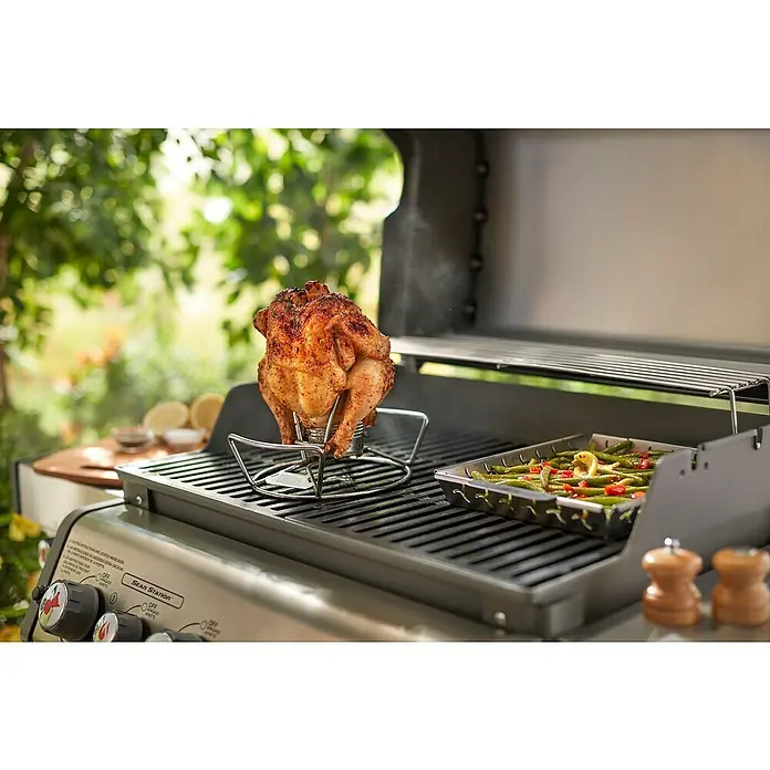 Weber Geflügelhalter - Edelstahl - Ein saftiges Brathähnchen auf einem Grill, zubereitet mit Gemüsebeilage. Perfekt für ein sommerliches BBQ im Freien.