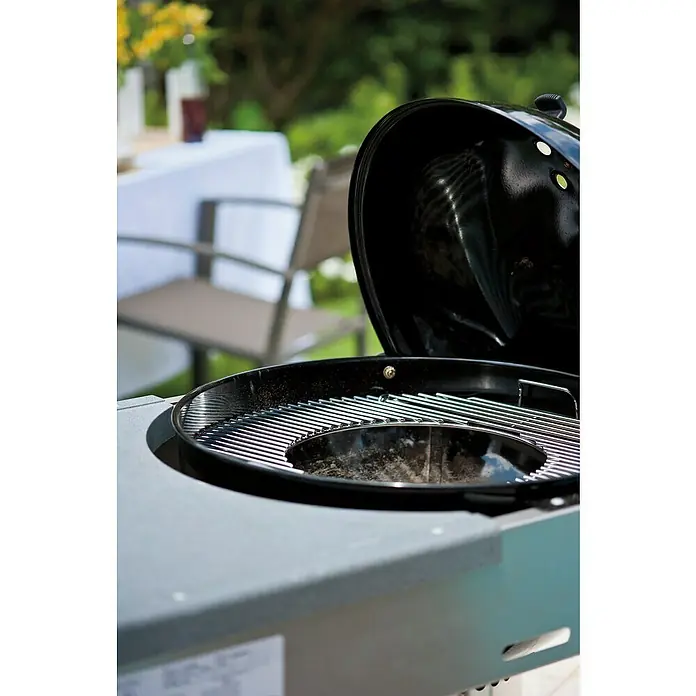 Weber Gourmet BBQ System Parrilla para barbacoa - L x An: 56,61 x 54,61 cm, Diámetro: 57 cm, Acero cromado - Primer plano de una parrilla de carbón redonda abierta con una rejilla, lista para aventuras de parrilla al aire libre.