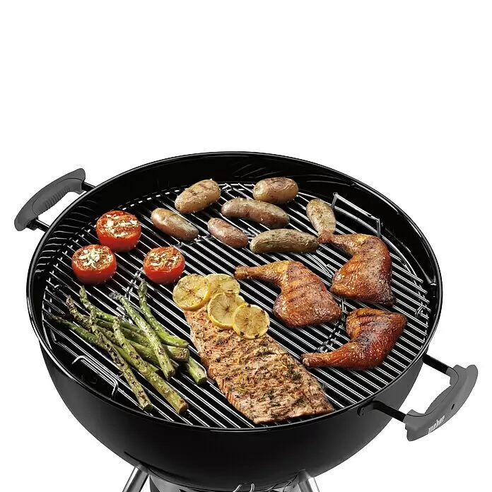 Weber Gourmet BBQ System Parrilla para barbacoa - L x An: 56,61 x 54,61 cm, Diámetro: 57 cm, Acero cromado - Barbacoa de carbón negra con salmón, pollo, espárragos, tomates, patatas y salchichas en la parrilla.