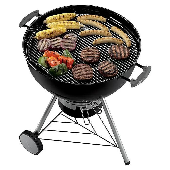 Weber Gourmet BBQ System Parrilla para barbacoa - L x An: 56,61 x 54,61 cm, Diámetro: 57 cm, Acero cromado - Una barbacoa de carbón negra con patas plateadas, cargada de maíz, salchichas, hamburguesas y verduras en la parrilla de acero inoxidable.