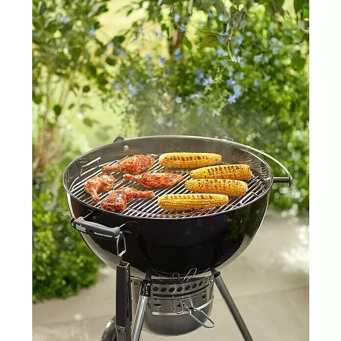 Weber Gourmet BBQ System Grillrost - L x B: 56,61 x 54,61 cm, Durchmesser: 57 cm, Verchromter Stahl - Schwarzer Weber-Grill mit Hähnchenkeulen und Maiskolben im Freien.
