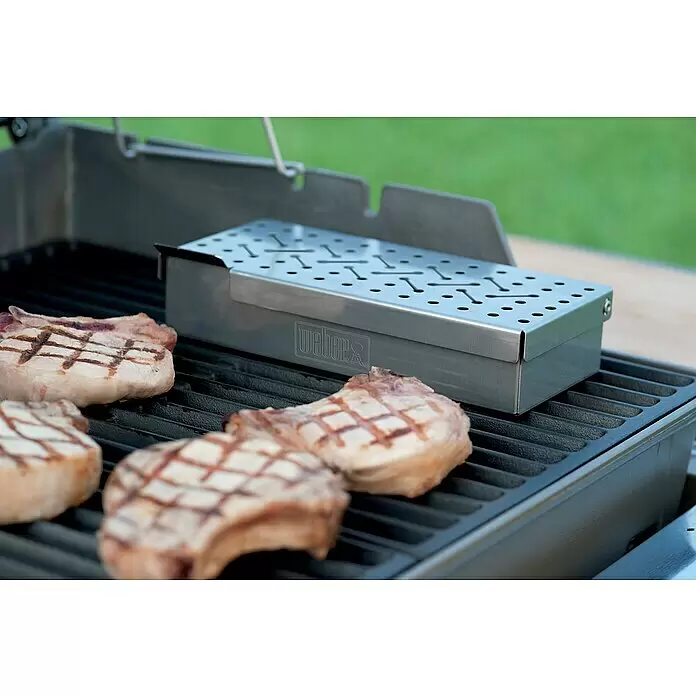 Weber Original Räucherbox - L x B x H: 24,5 x 12 x 5,1 cm - Edelstahl Weber Räucherbox auf Grill mit Koteletts.