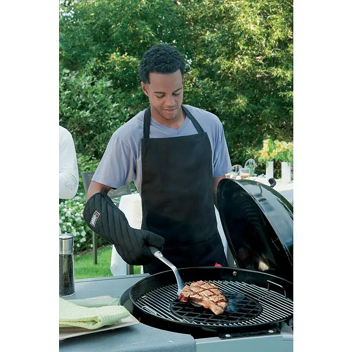 Weber Gourmet BBQ System Grillrost Sear Grate - L x B: 30 x 30 cm, Durchmesser: 30 cm, Gusseisen - Ein Mann grillt ein Steak auf einem Weber Grill mit Grillhandschuh und Zange.