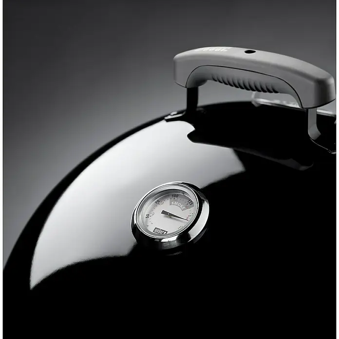 Weber Räucherofen Smokey Mountain CookerDurchmesser Grillfläche: 47 cm, Schwarz - Detailaufnahme eines Weber Grills mit Fokus auf Deckelthermometer und Griff, das elegante Design und die hohe Qualität betonend.