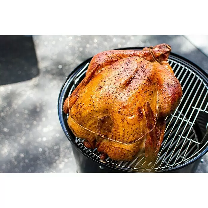Weber Ahumador Mountain Cooker - Diámetro de la superficie de la parrilla: 47 cm, Negro - Pavo asado dorado, sazonado y atado, sobre una rejilla de parrilla negra.